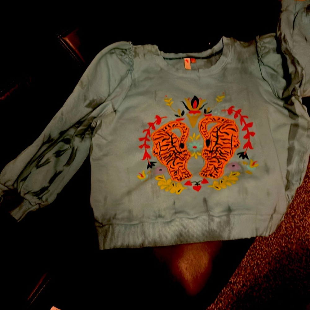 Actual color is more of an aqua-turquoise. Tigers are sewn on. Tie dyed sleeves